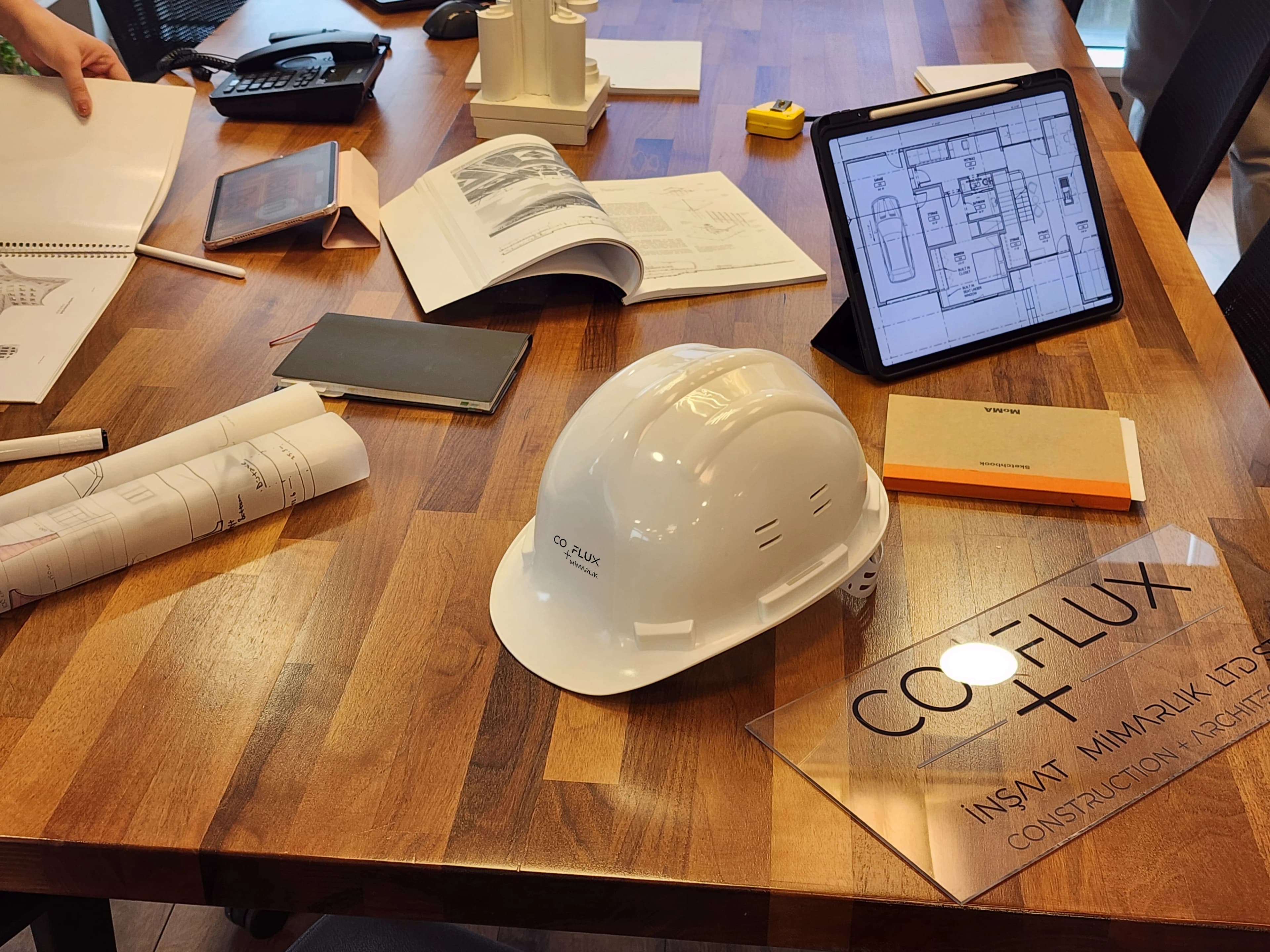 CO-FLUX baret ve glass etching ile editorial brand detayı — masada plan ve ölçü aletleri