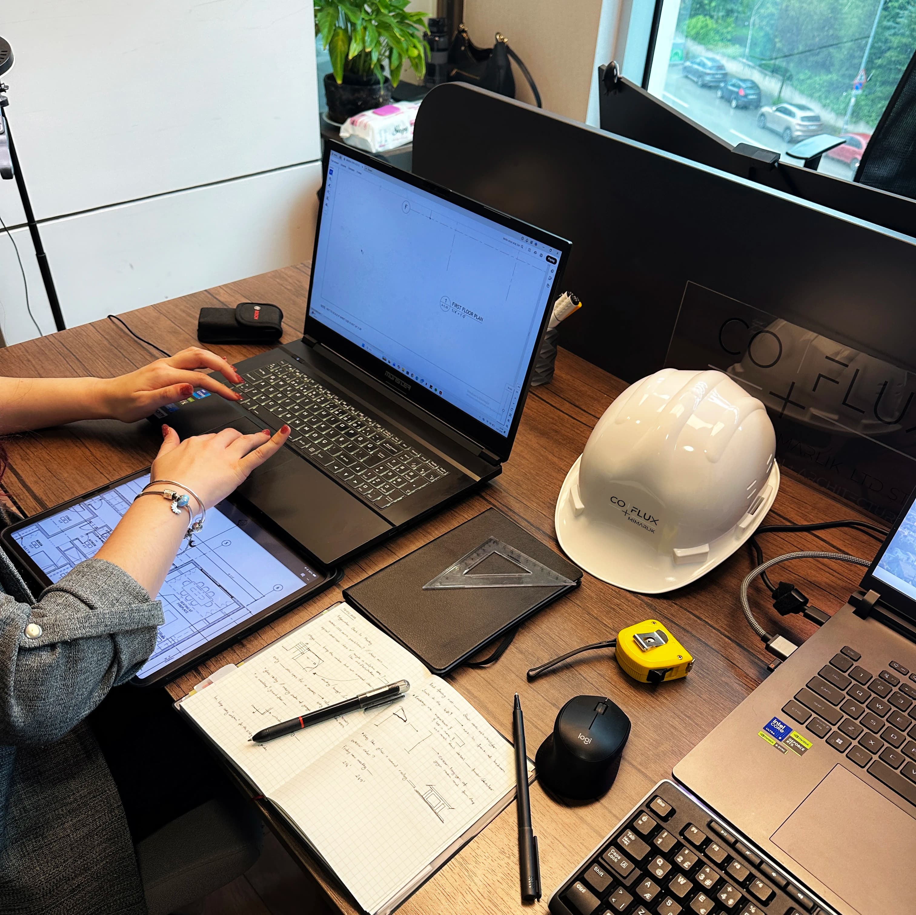 Yatak odasında masada çalışma — laptop, plan, Coflux baret yan yana
