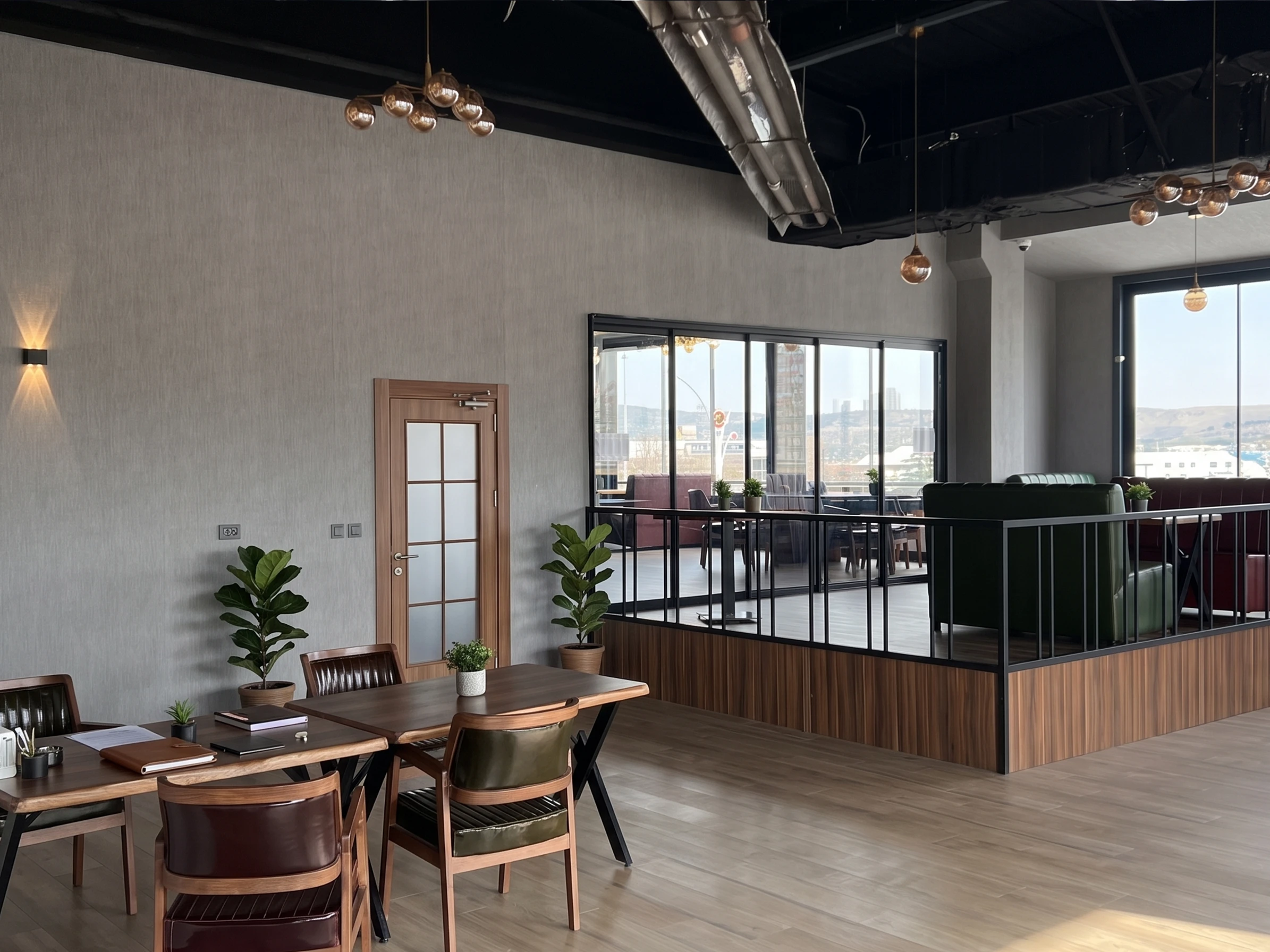 Kafe ve lounge katı — ahşap zemin, cam korkuluklu seyir terası ve Gölbaşı manzarası